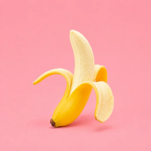 A peeled banana set against bubblegum pink.