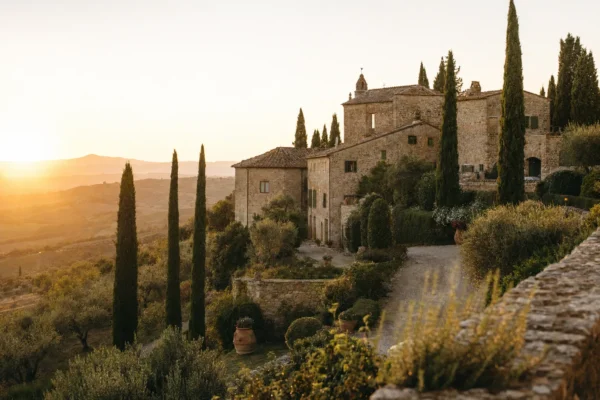 Tuscan hillside at sunset with a stone villa, cypress trees and olive groves on a countryside wedding day