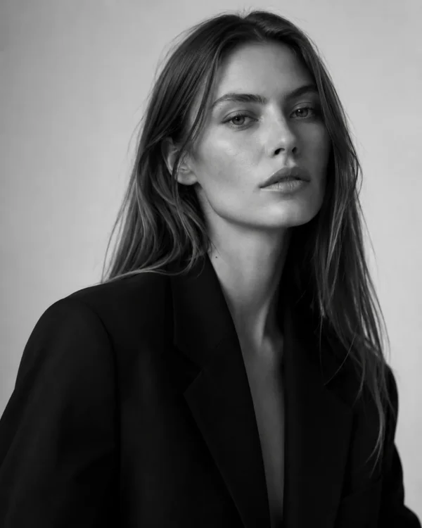 Close beauty portrait of a model in a black blazer with loose hair, black-and-white editorial fashion