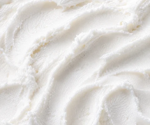 Pure soft white coconut gelato with creamy ridged peaks in close-up