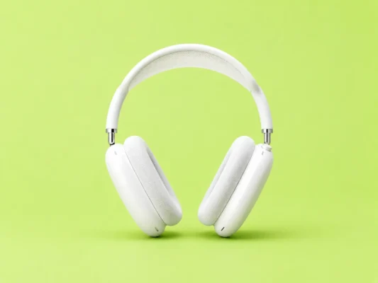 White over-ear headphones floating against a bright lime-green background