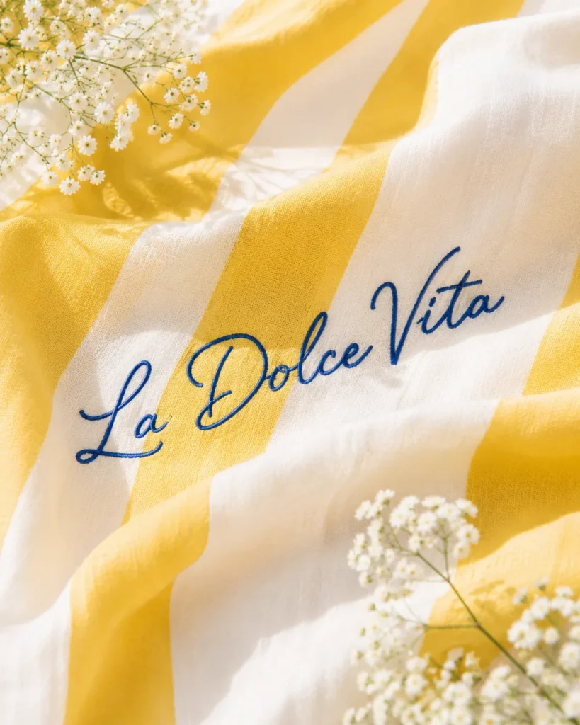 Yellow and white striped cloth embroidered with La Dolce Vita and baby's breath
