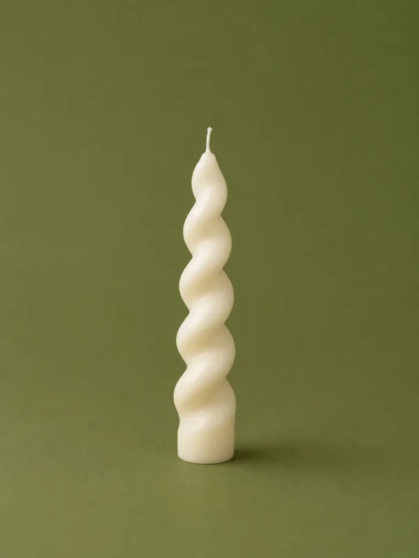 Cream twisted spiral candle standing upright on a deep olive green background