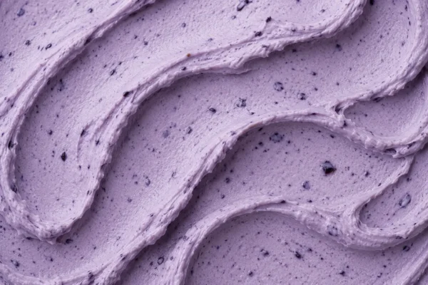 Lavender-blue blueberry gelato flecked with darker fruit pieces close-up
