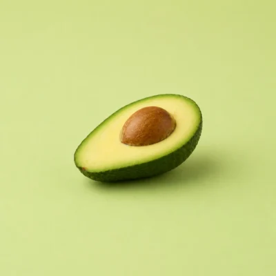 Halved avocado showing the stone, centered on a flat olive-green background