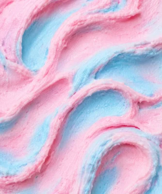 Pastel pink and blue cotton candy gelato in a soft swirled close-up