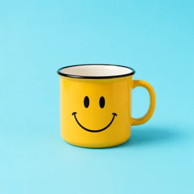 Yellow smiley-face mug with a handle centered on a deep blue background