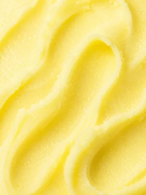 Bright pale yellow lemon sorbet with an icy crystalline surface close-up