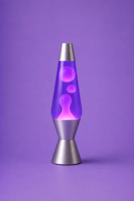 Purple lava lamp glowing against a two-tone blue and pink studio background