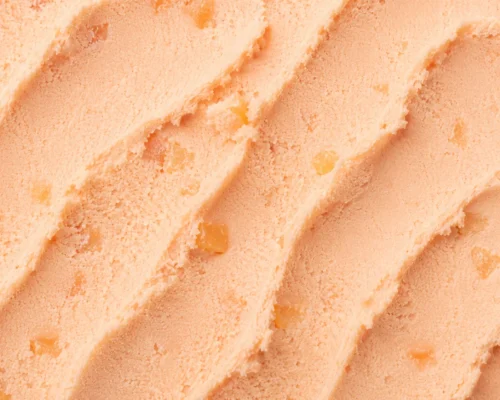 Soft warm peach gelato with a creamy smooth surface in macro close-up